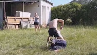 a man is laying on the ground in front of a house