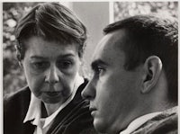 a black and white photo of a man and woman looking at each other