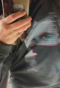 a person taking a picture of a shirt with a face on it